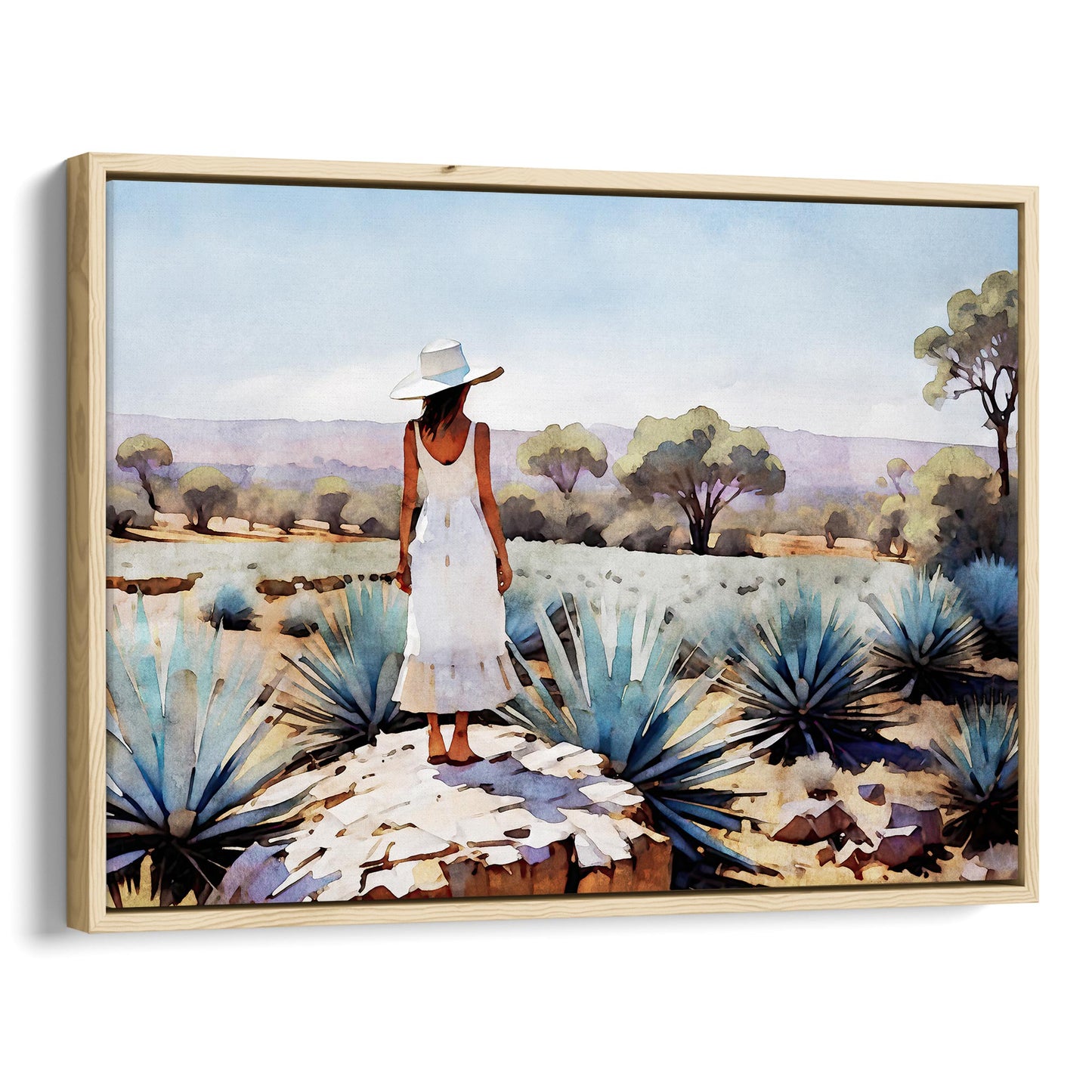 Natural wood framed canvas print of a woman in a white dress and hat standing on a rock in an agave field with trees and mountains in the background.