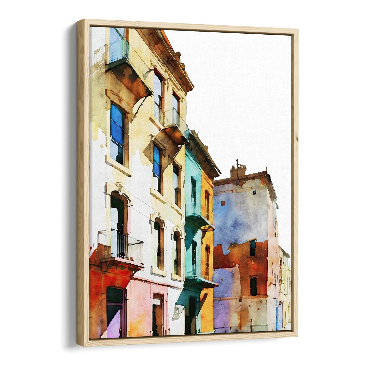 Framed canvas print of a watercolor painting showing colorful buildings with pastel facades, set in a natural wood frame.