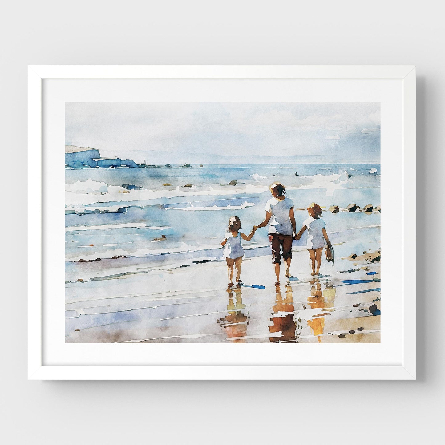 Framed watercolor painting of a woman and two children walking along the shoreline, mounted on a white wall with a white frame.