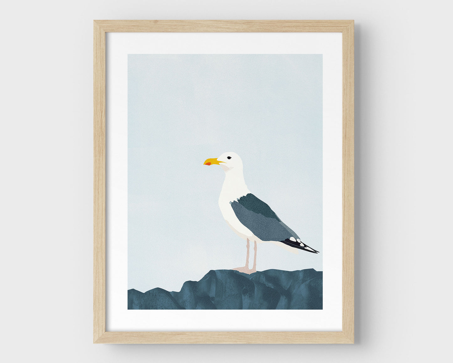 Minimalist illustration of a seagull perched on a dark blue rock against a pale blue sky, framed in natural wood with a white border.