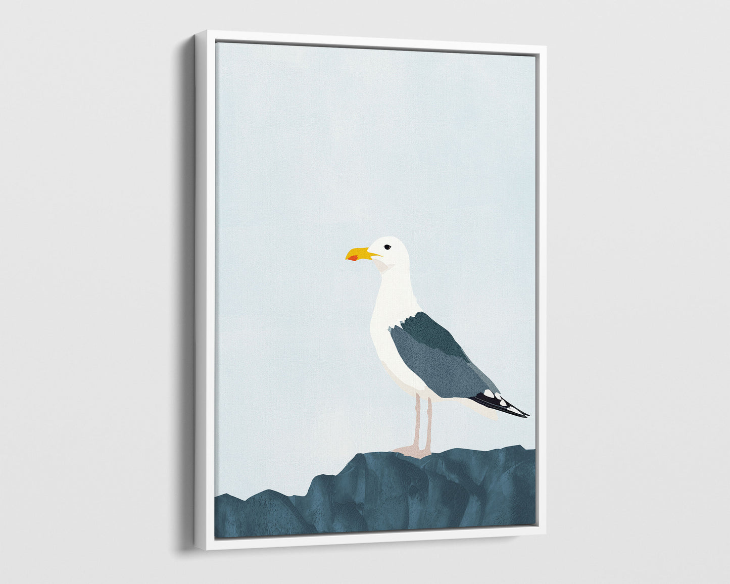 White framed canvas print of a minimalist illustration of a seagull standing on a dark blue rock against a pale blue background.