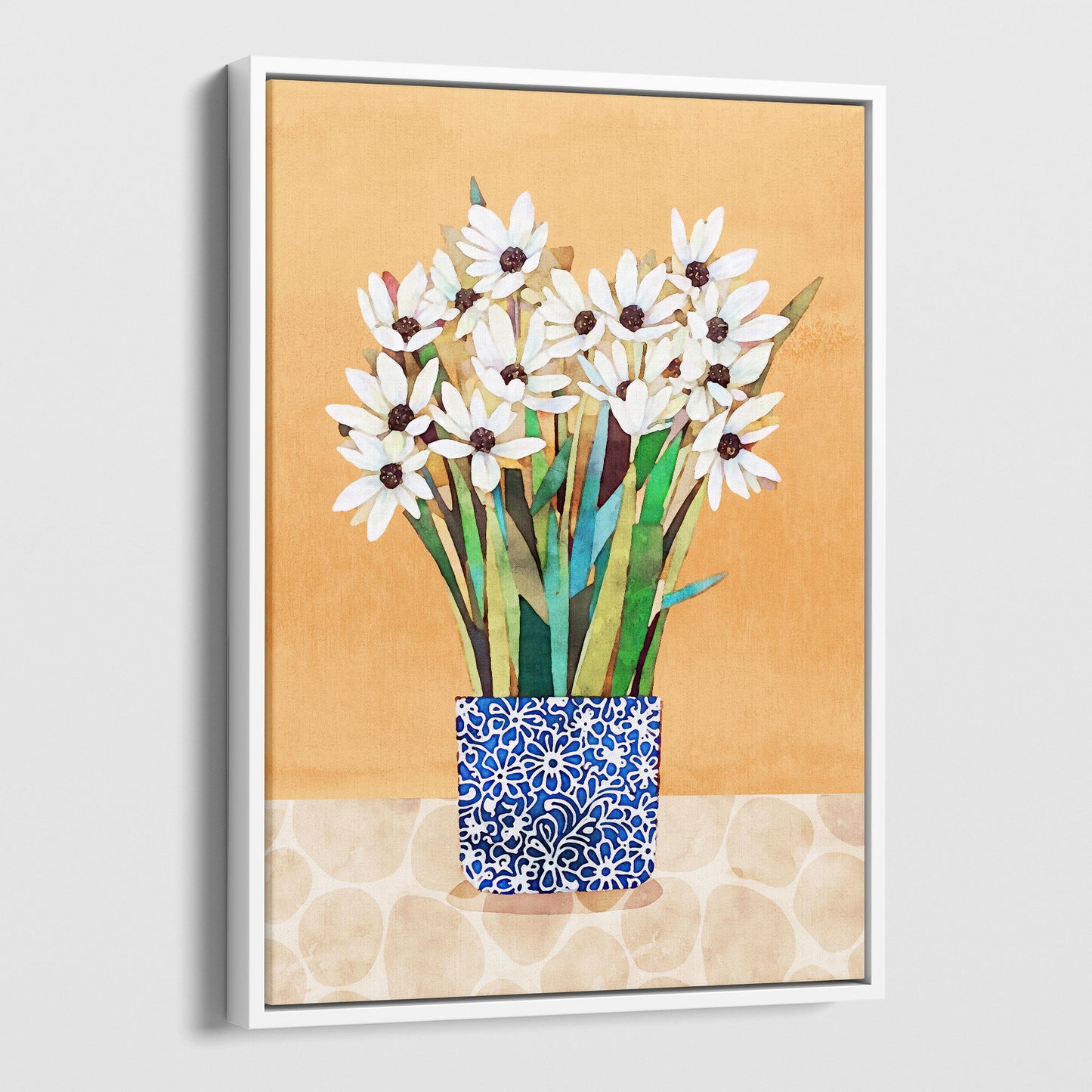 White framed canvas artwork featuring white flowers with dark centers in a blue patterned vase on a beige patterned surface with an orange background.
