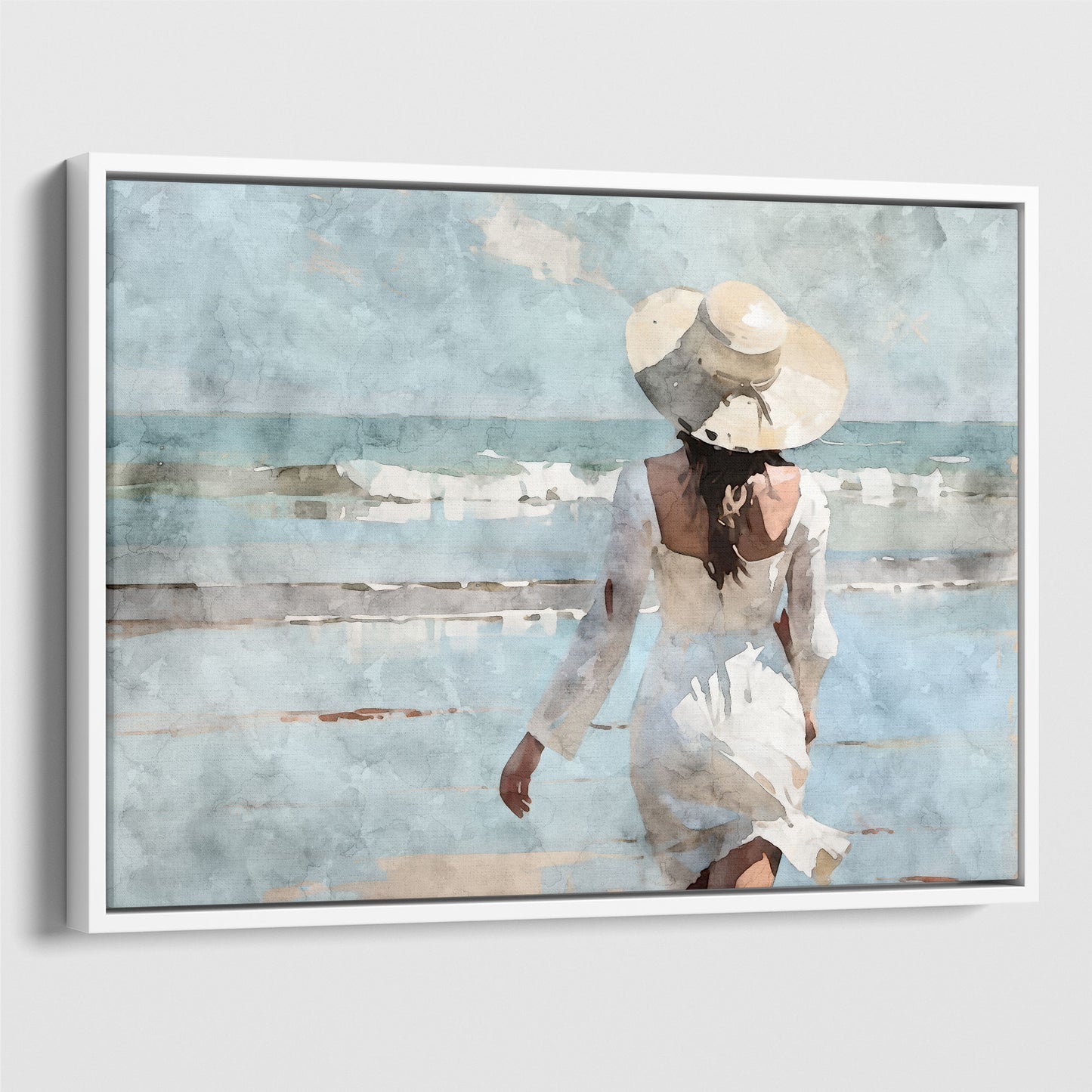 Watercolor painting of a woman in a white dress and wide-brimmed hat walking toward the ocean on a sandy beach, with waves in the background. Artwork printed on gallery wrap canvas in white floater frame.