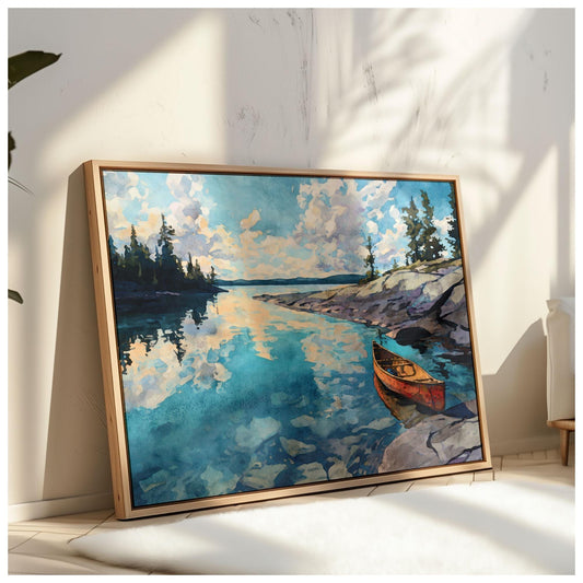 Framed painting of a tranquil lake scene propped against a wall, showing a red canoe resting on rocky shore, calm turquoise water reflecting clouds and pine trees under a bright sky. Sunlight and plant shadows fall across the wall, adding a warm, natural atmosphere.