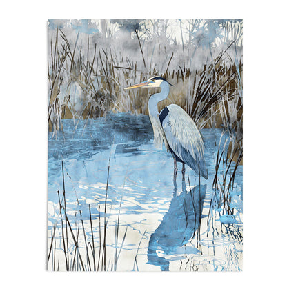 Watercolor-style art print of a heron standing in calm blue water surrounded by tall reeds, its reflection stretching across the rippling surface. The piece features soft blue, gray, and brown tones, capturing a tranquil wetland scene.