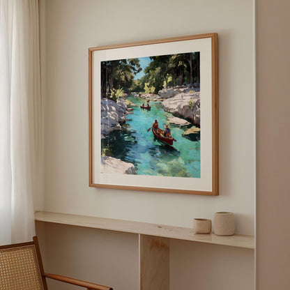 Framed painting of two people paddling a red canoe on a turquoise river with rocky cliffs and trees, hanging on a neutral wall in a softly lit modern room with light wood accents and minimal decor.