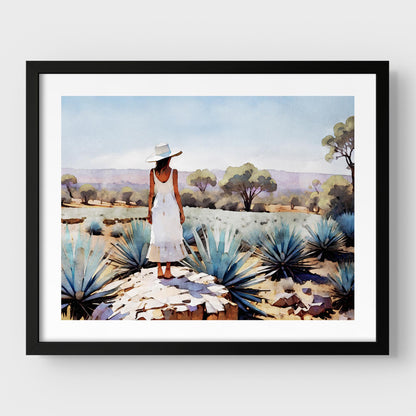 Black framed artwork of a woman in a white dress and hat standing in an agave field.