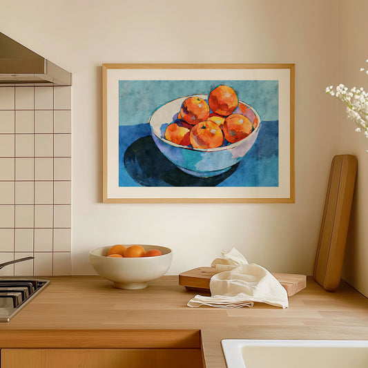 Framed artwork of a bowl of oranges in a kitchen setting