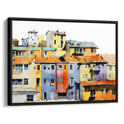 Framed canvas print of a watercolor painting showing a colorful hillside village with vibrant buildings, set in a black frame.