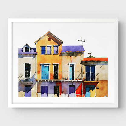 Framed watercolor painting of colorful buildings with blue, yellow, and purple facades, mounted on a white wall with a white frame.