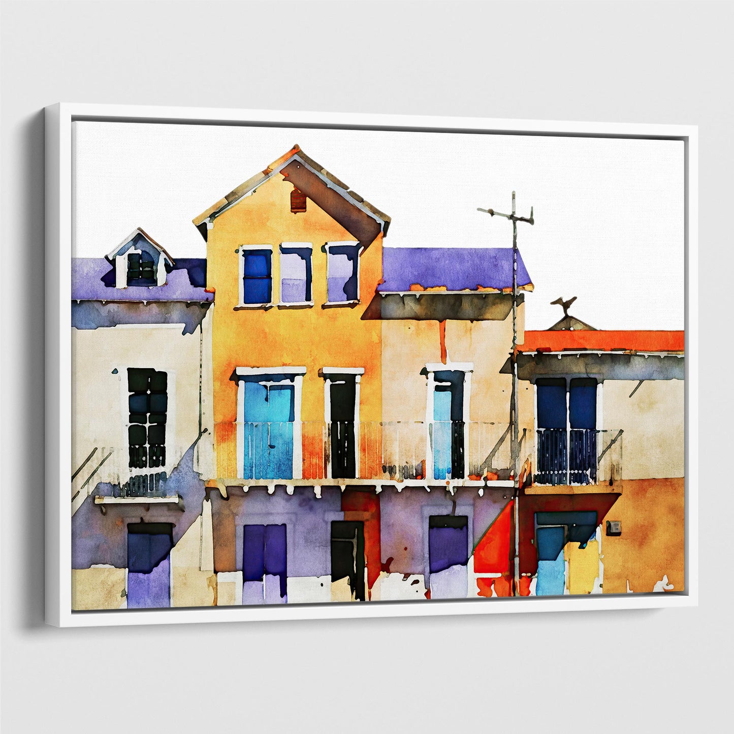 Framed canvas print of a watercolor painting featuring colorful buildings with blue, yellow, and purple facades, set in a white frame.