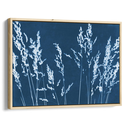Framed cyanotype print featuring white wild grass silhouettes against a deep blue background, enclosed in a sleek natural wood frame.