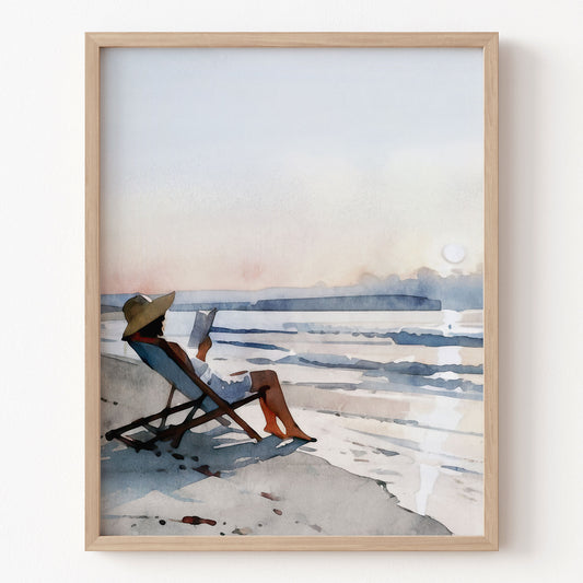 Framed artwork of a person sitting on a beach chair by the water.