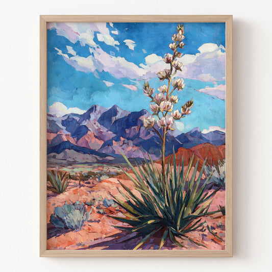 Framed artwork of a desert landscape with mountains and a plant.