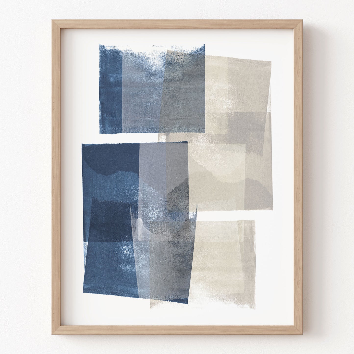 Framed abstract art with blue and beige squares on a white wall
