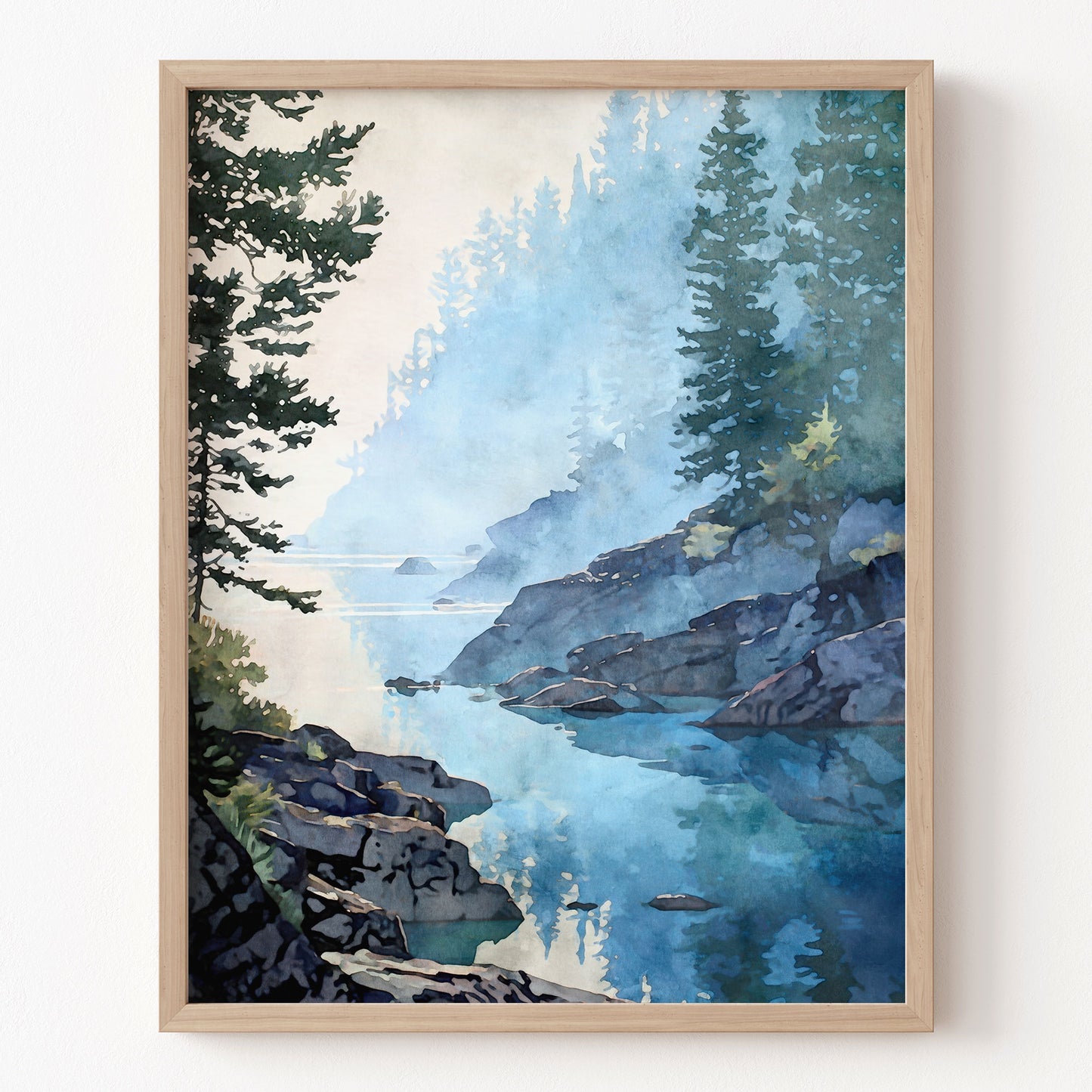 Framed artwork of a mountain landscape with a lake and trees on a white wall.