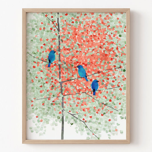 Framed artwork of blue birds on a branch with a colorful abstract background