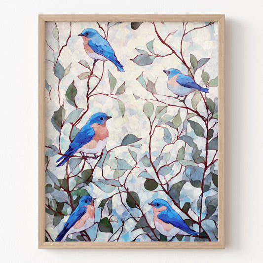 Framed artwork of blue birds on branches with leaves on a white wall