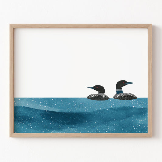 Framed artwork of two loons on a blue water surface with a white background