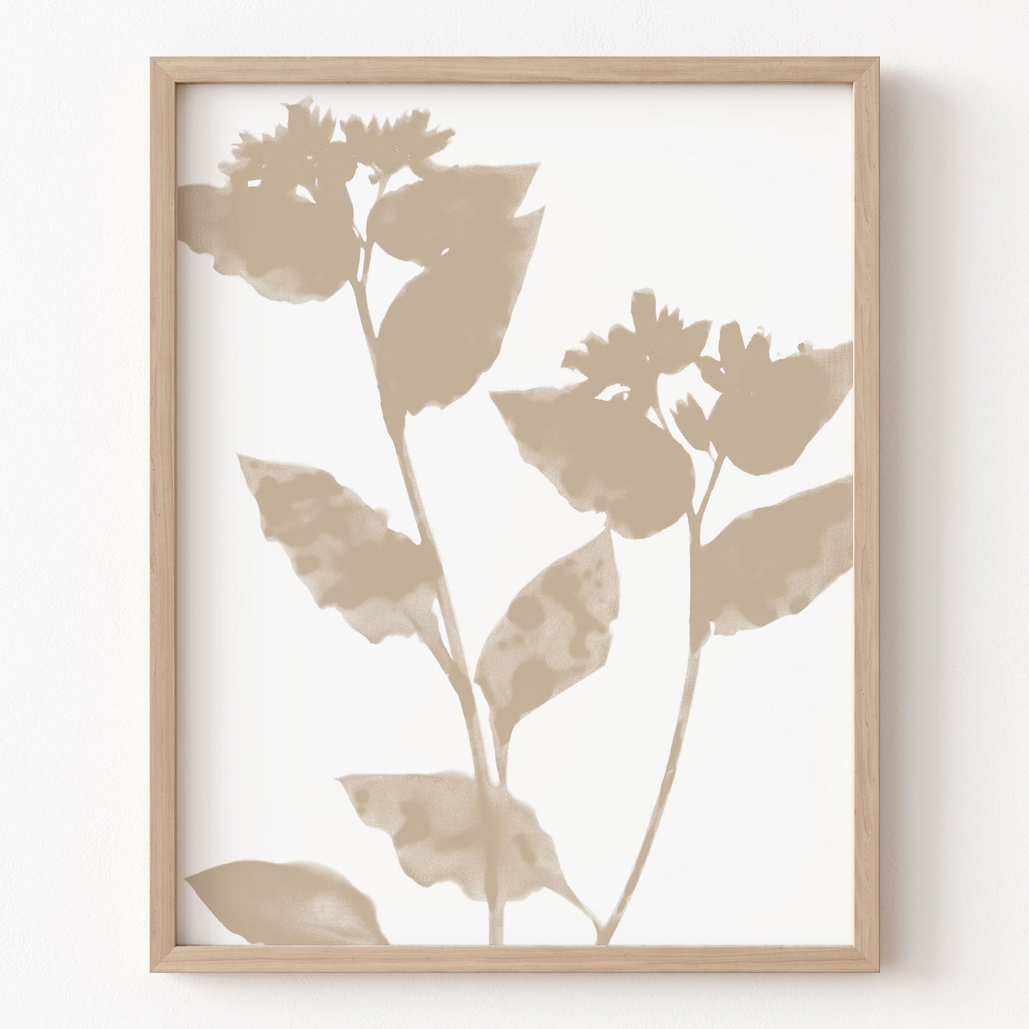 Framed artwork with beige leaf silhouettes on a white background