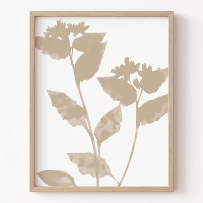 Framed artwork with beige leaf silhouettes on a white background