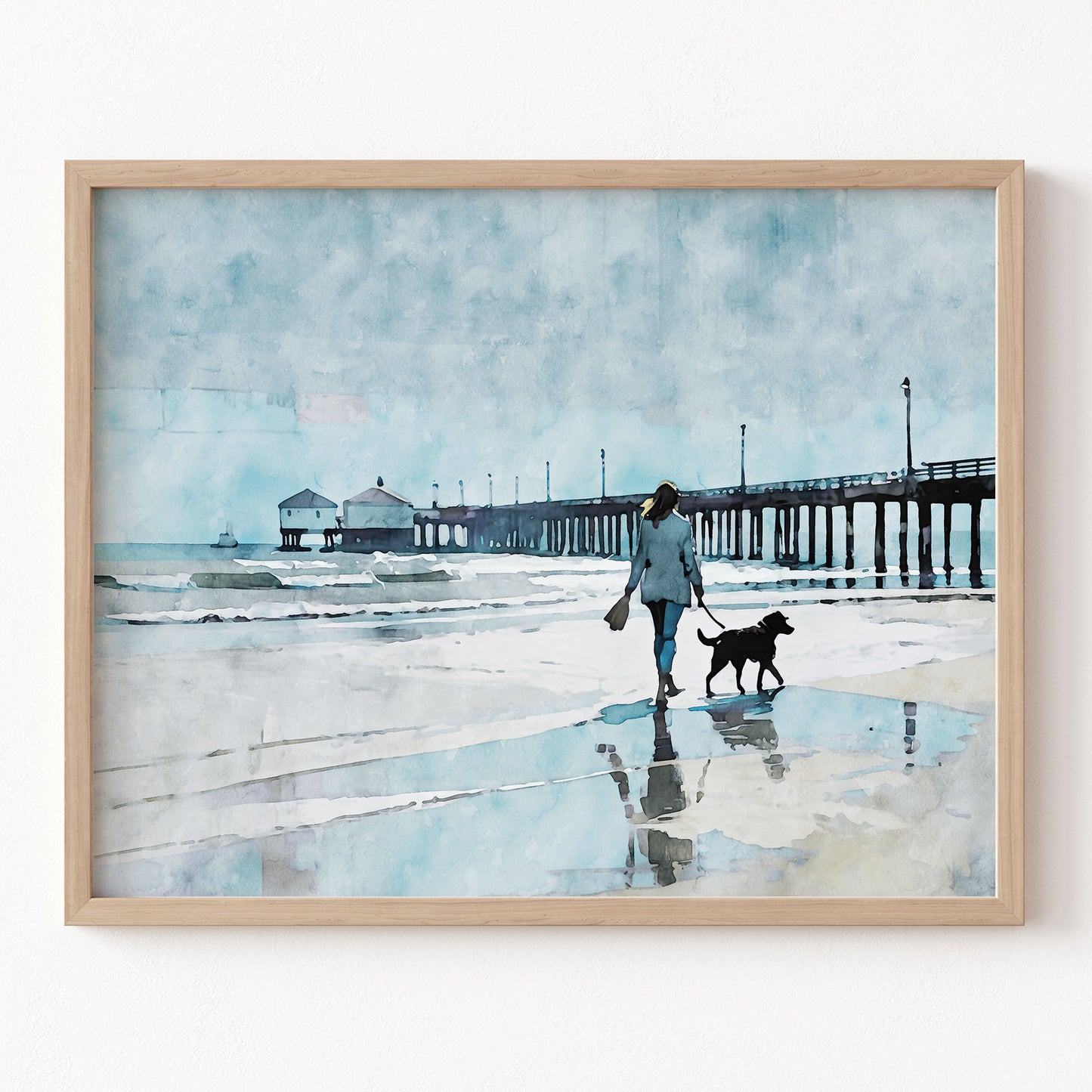 Framed artwork of a person walking a dog on a beach with a pier in the background.