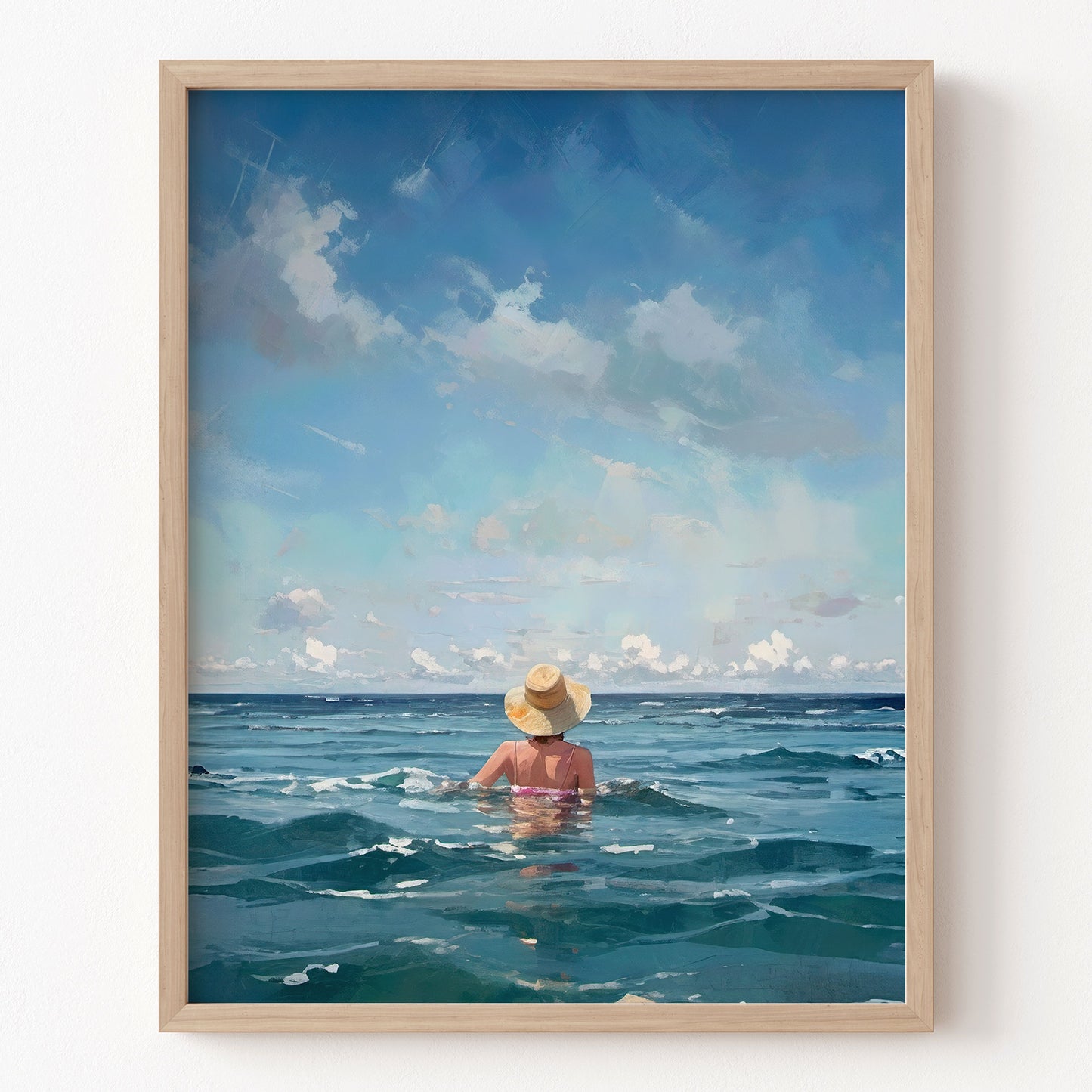 Framed artwork of a person in a swimsuit and hat sitting in the ocean with a blue sky.
