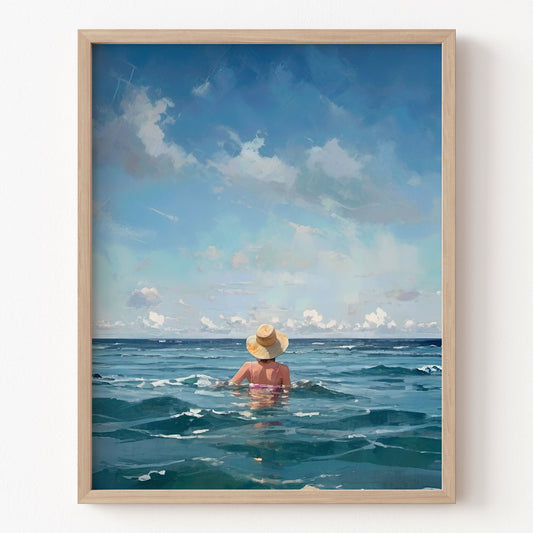 Framed artwork of a person in a swimsuit and hat sitting in the ocean with a blue sky.