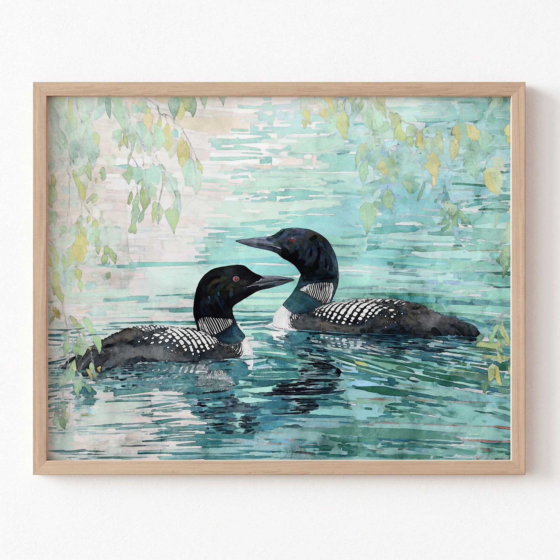 Framed artwork of two loons swimming in water with a light blue and green background.