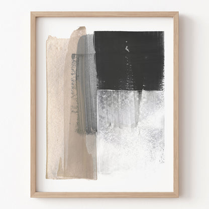 Abstract art print with black, white, and beige brush strokes in a wooden frame on a white wall.