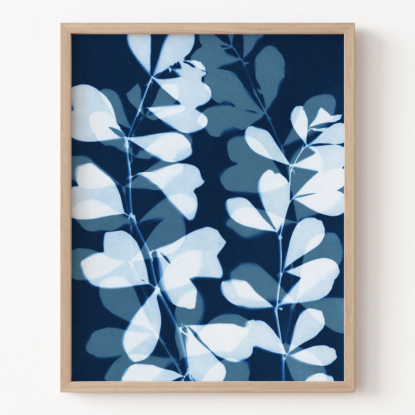 Framed artwork with blue and white leaf pattern on a dark blue background