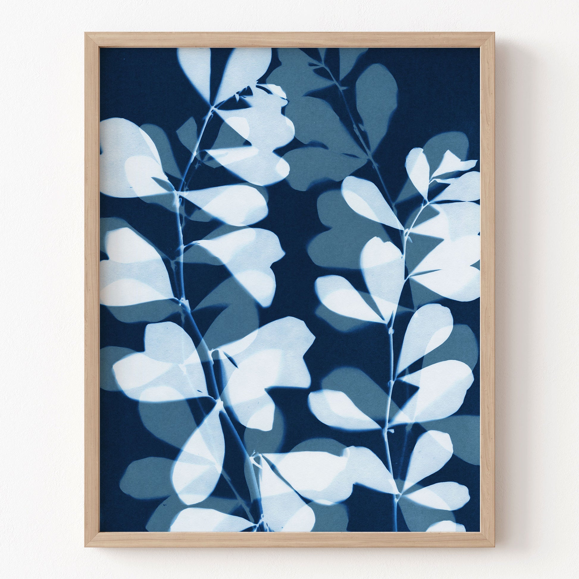 Framed artwork with blue and white leaf pattern on a dark blue background