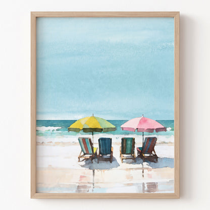 Framed artwork of a beach scene with colorful umbrellas and chairs.