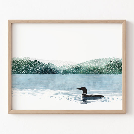 Framed artwork of a loon on a lake with trees in the background