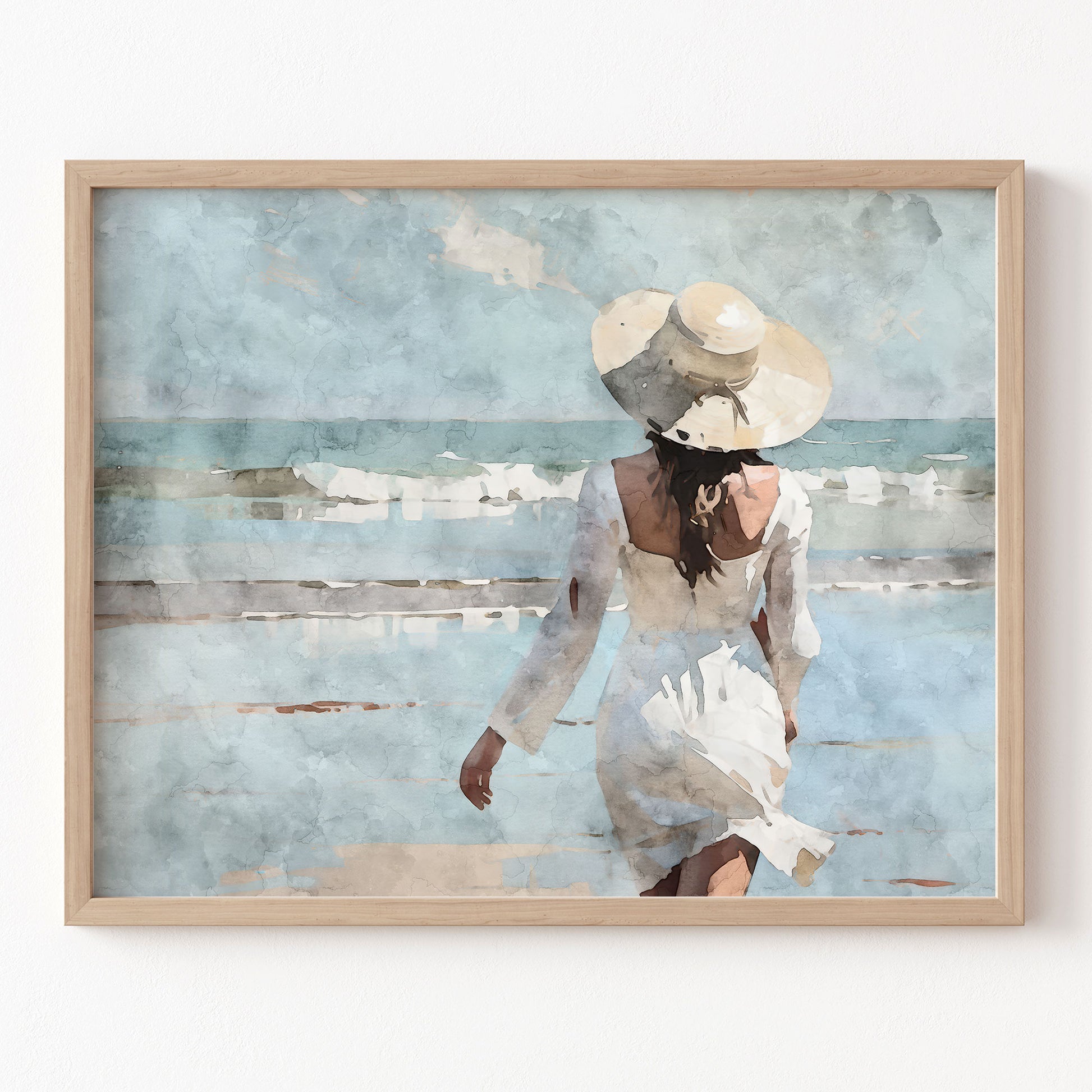 Framed artwork of a woman in a white dress and hat on a beach.