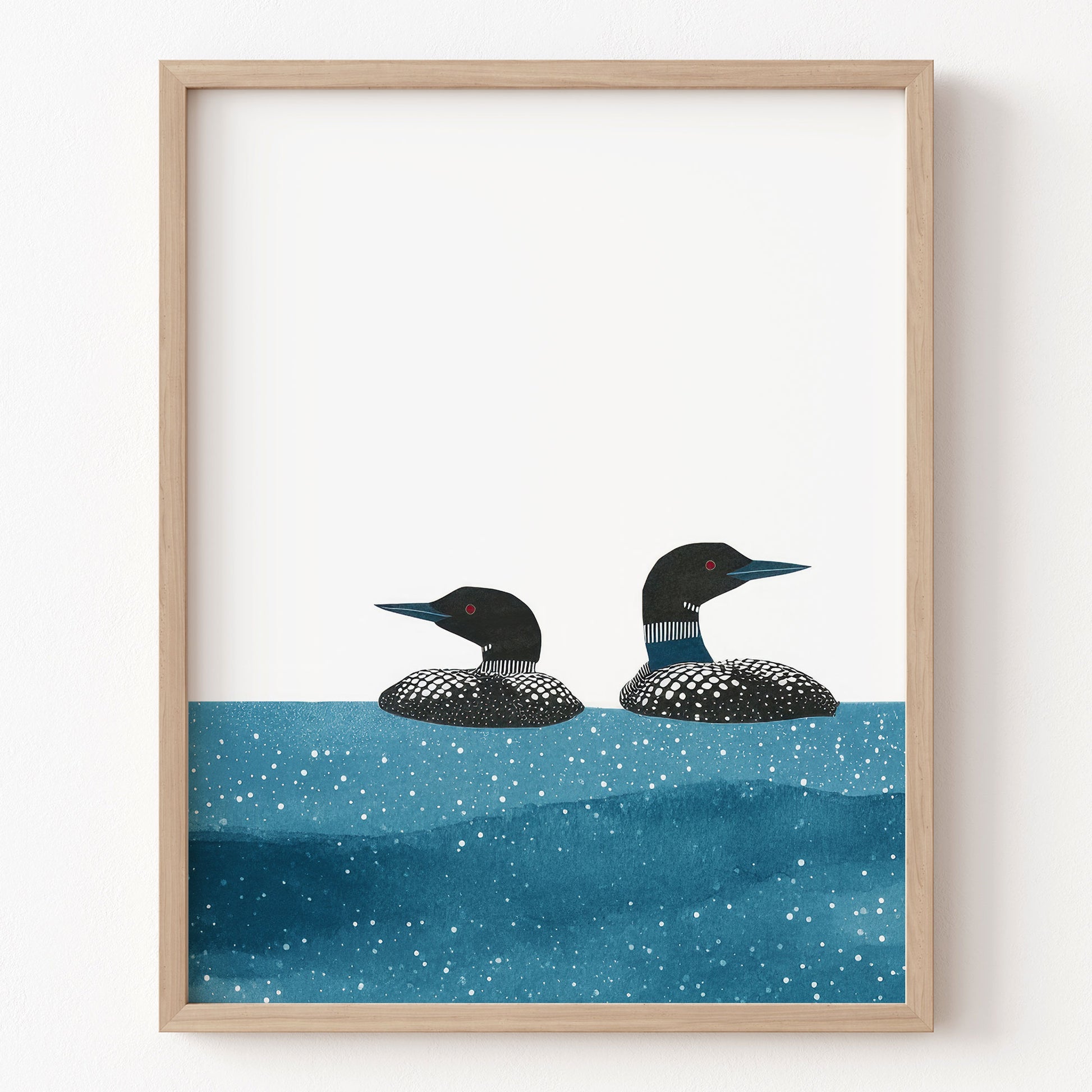 Framed artwork of two loons on water with a white background