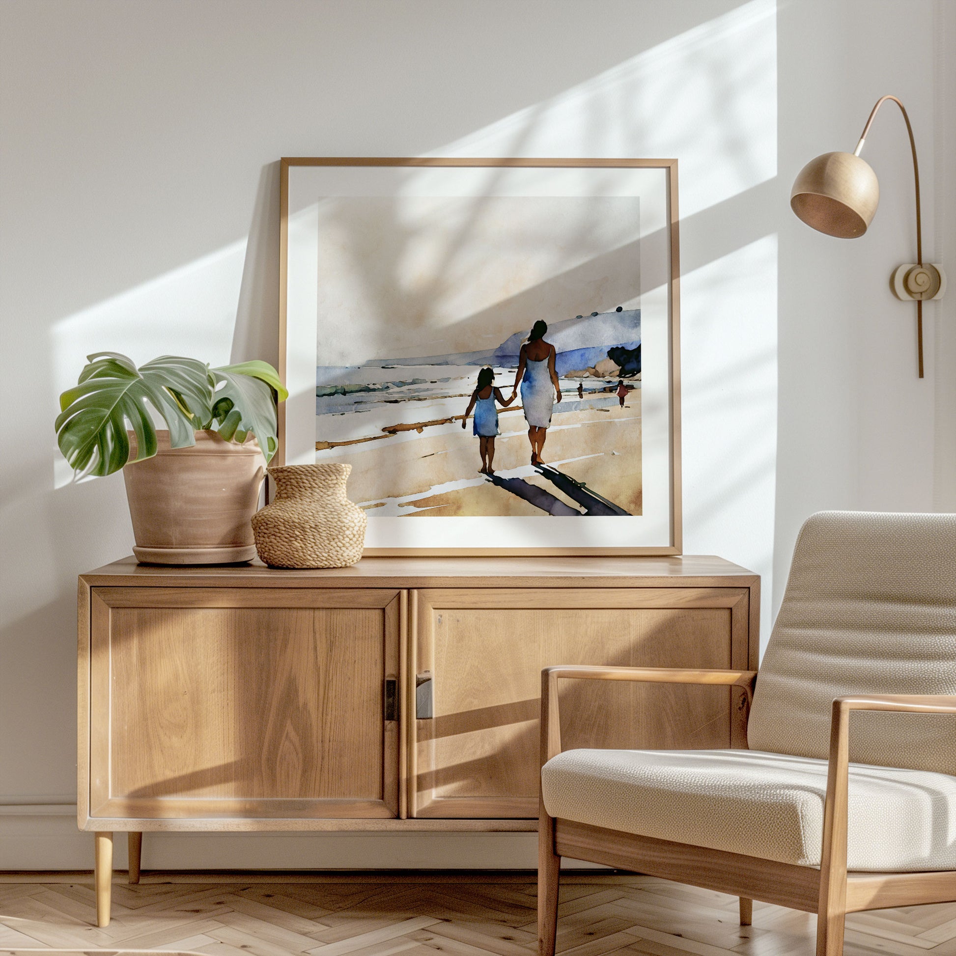 Sunlit corner with a wooden sideboard, potted monstera plant, woven vase, beige armchair, and a framed beach painting on the wall.