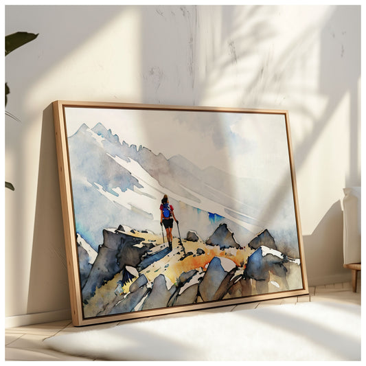 A framed artwork of a hiker on a rocky mountain path leans against a sunlit wall, with soft shadows cast by nearby plants.