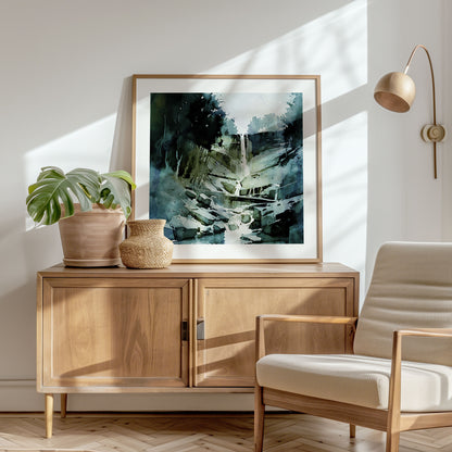 Framed watercolor painting of a waterfall, placed on a wooden sideboard in a sunlit room with a plant and a beige armchair.
