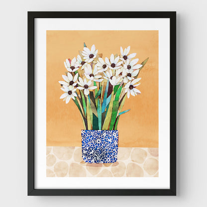 Print of white flowers with dark centers in a blue patterned vase on a beige patterned surface with an orange background, set in a black frame.