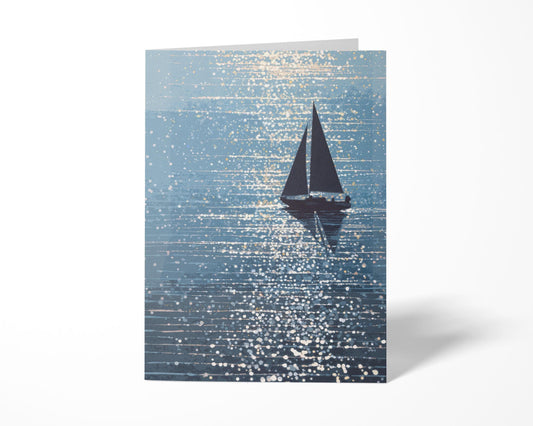 Folded greeting card standing upright on a white background, featuring a silhouetted sailboat gliding through sparkling blue water under dappled sunlight. The painterly design captures a tranquil, nautical mood with glints of light scattered across the surface.
