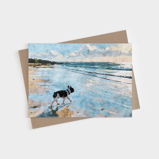 Pied French Bulldog walking through shallow beach water in a soft blue watercolor coastal scene on a blank folded greeting card with kraft envelope.